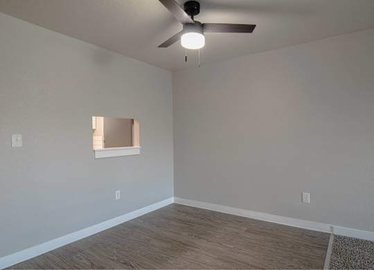 A room with a ceiling fan and a window.