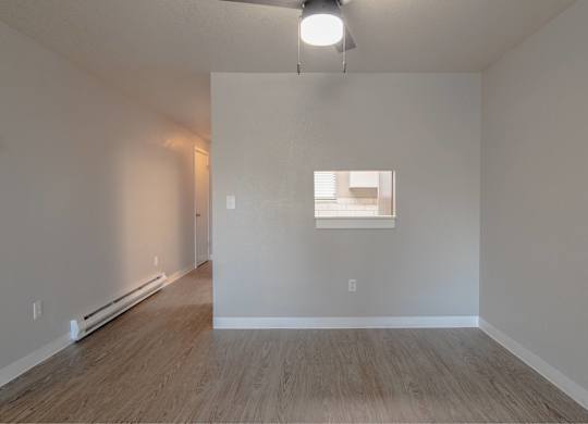 A room with a window and a wooden floor.