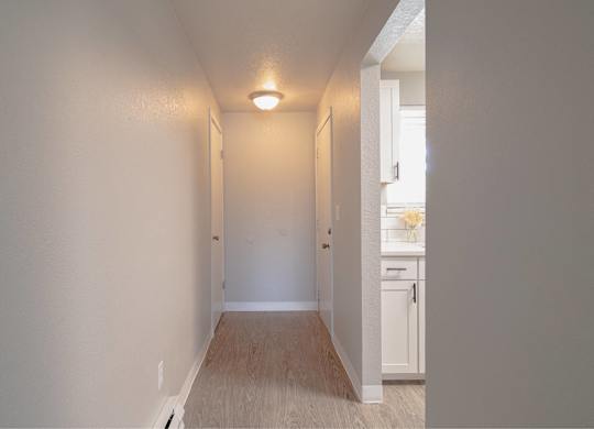 A long hallway with a light on the ceiling and a door on the right.