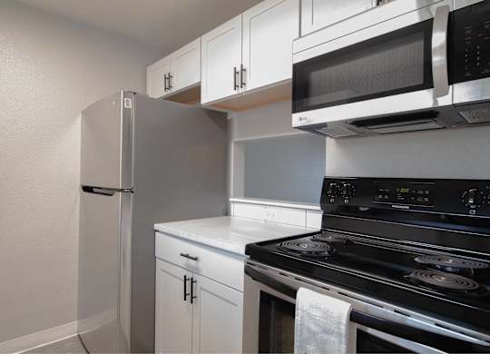 A kitchen with white cabinets and a black stove top oven.