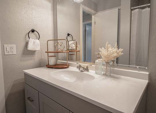 A white bathroom sink with a white towel hanging on the towel ring.