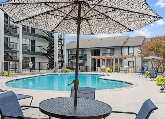 Resort style pool deck with pergola and lounge chairs at Peaks at Live Oak Apartments, San Antonio