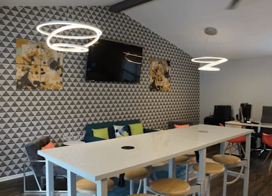 Collaborative workspace with conference table and computer stations at Peaks at Live Oak Apartments, Texas
