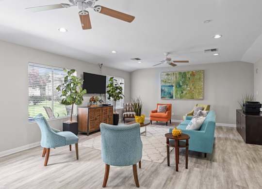 Community lounge with colorful seating and ceiling fans at Peaks at Universal City Apartments, Texas, 78148