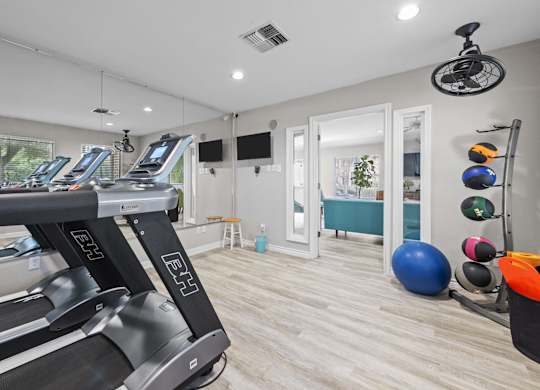 Fitness center with cardio equipment and exercise accessories at Peaks at Universal City Apartments, Universal City, TX