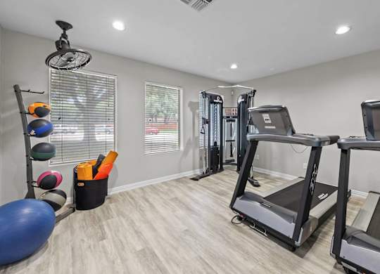 Fitness center with treadmills and weight machines at Peaks at Universal City Apartments, Universal City, Texas