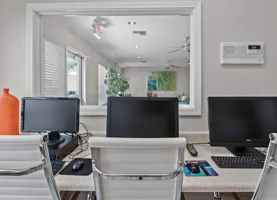Office workspace with multiple computer stations at Peaks at Universal City Apartments, Texas