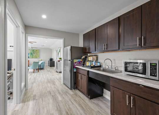 Modern kitchen with stainless steel appliances and dark wood cabinetry at Peaks at Universal City Apartments, Universal City, TX 78148