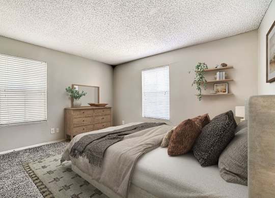 Spacious bedroom with wooden dresser and floating shelves at Peaks at Universal City Apartments, Universal City, TX