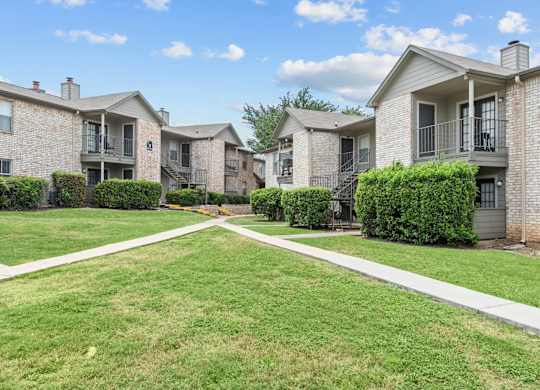 Courtyard with sidewalks and apartment buildings at Peaks at Universal City Apartments, Universal City, Texas