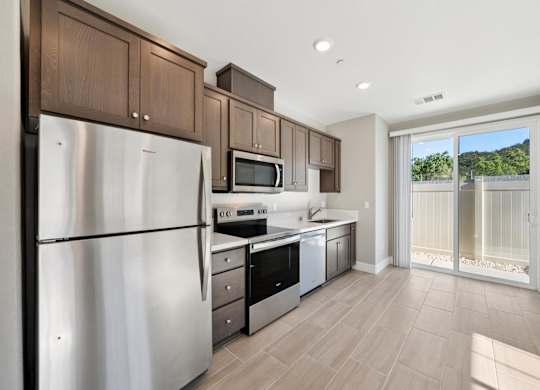 A Kitchen with a Stainless Steel Refrigerator at Montessa Apartments, California