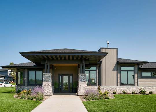 A modern house with a stone pillar in front of the entrance.