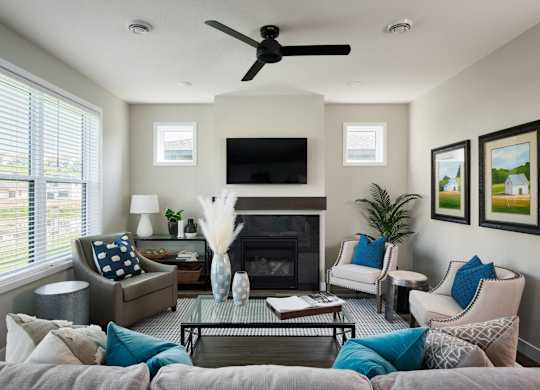 A living room with a grey couch, a fireplace, and a television.