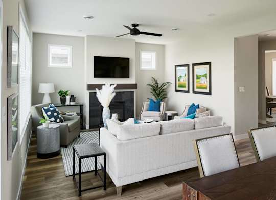 A living room with a white couch, a fireplace, and a television.