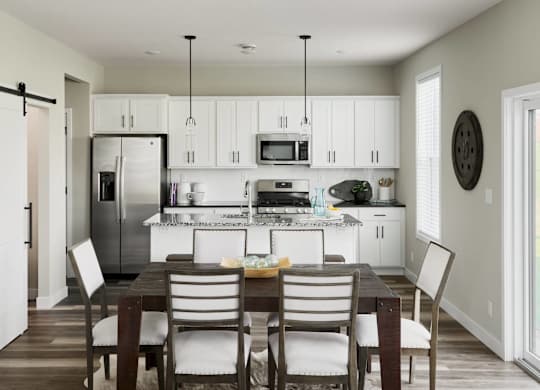 A modern kitchen with a dining table and chairs.