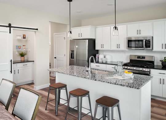 A modern kitchen with white cabinets and a granite countertop.