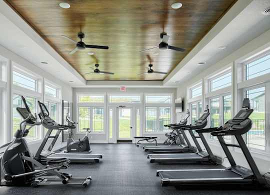 A gym with treadmills and a ceiling fan.