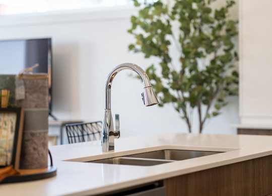 A kitchen sink with a chrome faucet.