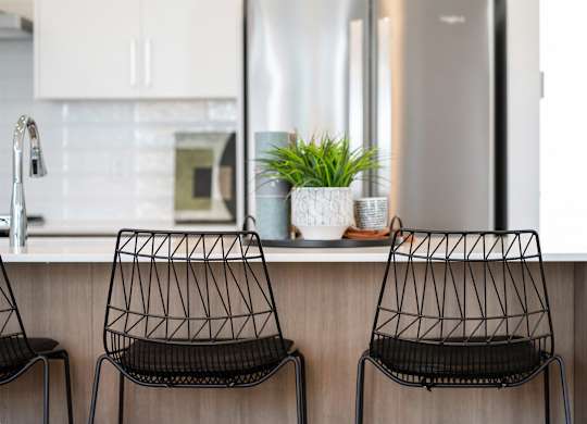 Two black chairs are placed in front of a kitchen counter.