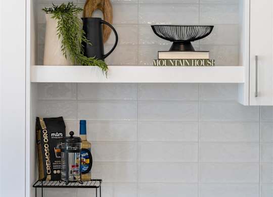 A kitchen cabinet with a white interior and shelves containing various items.