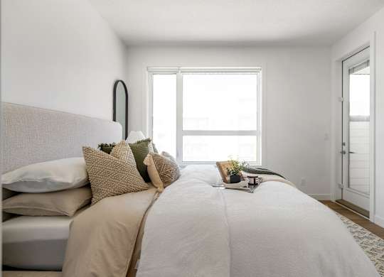 A bedroom with a large bed and a window.