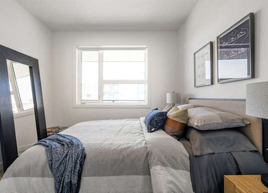 A bedroom with a large bed and a window.