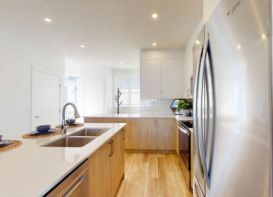 A modern kitchen with a stainless steel refrigerator and wooden cabinets.