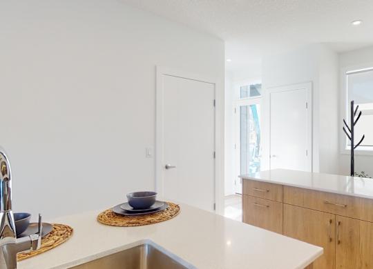 A kitchen with a white counter top and a sink.