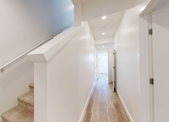 A long hallway with a staircase on the left side.