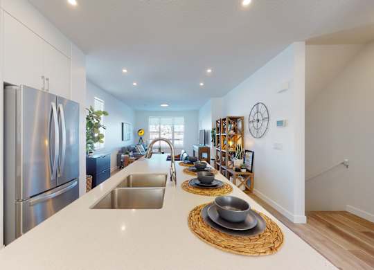 A modern kitchen with a stainless steel refrigerator and a wooden countertop.