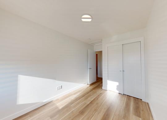 A room with a wooden floor and white walls.