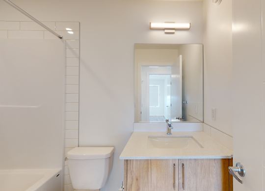 A white bathroom with a toilet, sink, and bathtub.