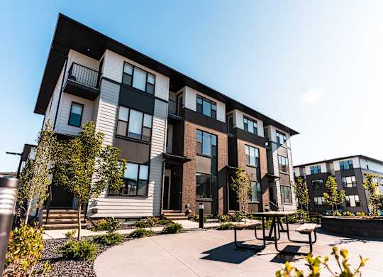 A modern apartment complex with a courtyard and seating area.