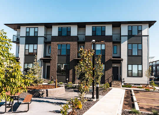 A modern apartment building with a courtyard and benches.