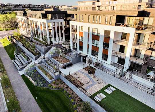 A modern building with a courtyard and a fence.