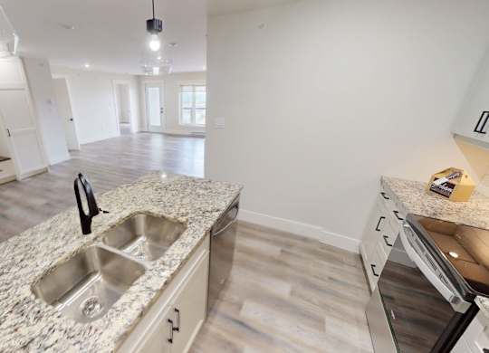 A kitchen with a granite countertop and stainless steel appliances.