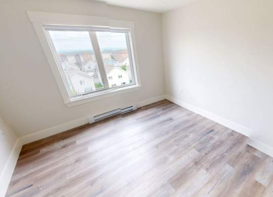 A room with a window overlooking a residential area.