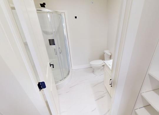 A white bathroom with a toilet and sink.