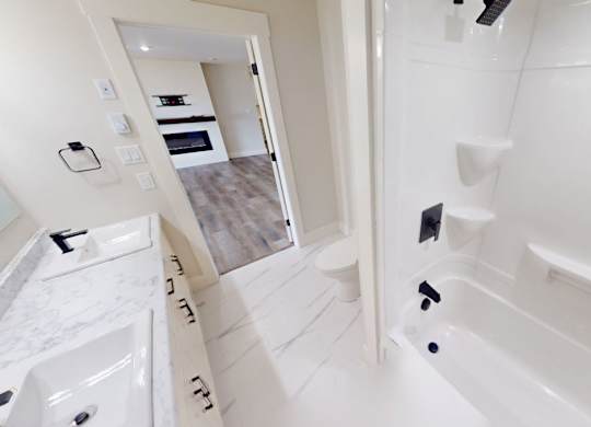 A white bathroom with a walk in shower and a sink.