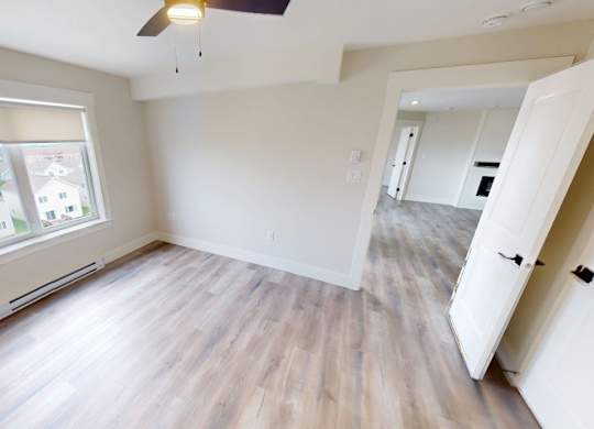 A room with a window and a ceiling fan.