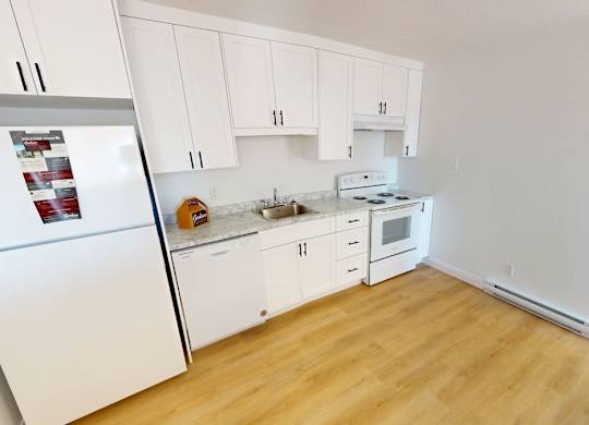 A kitchen with white appliances and cabinets.