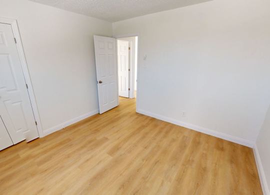 A room with two doors and a wooden floor.