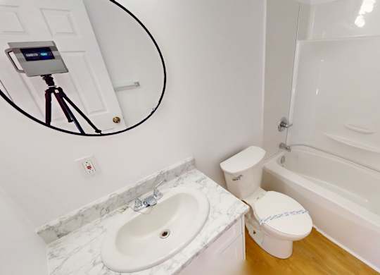 A bathroom with a white tub, toilet, and sink.