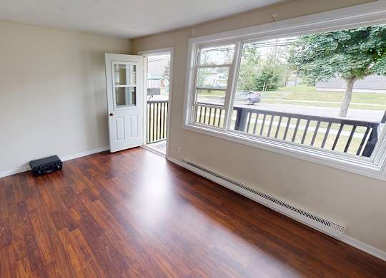 A room with wooden floors and a white door.
