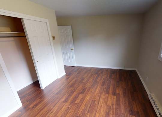 A room with wooden floors and a window.