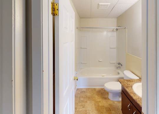 A bathroom with a toilet, sink, and bathtub.