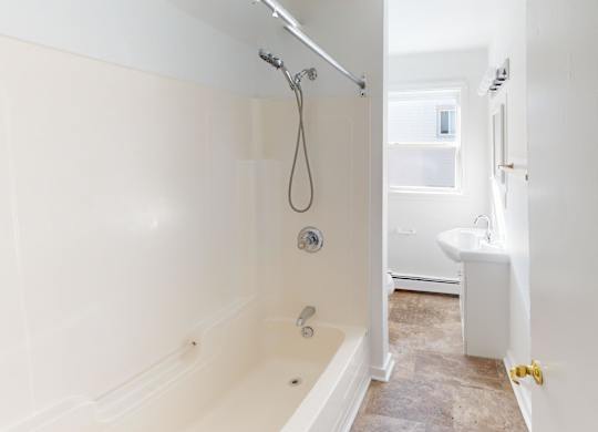 A white bathroom with a tub and a shower.