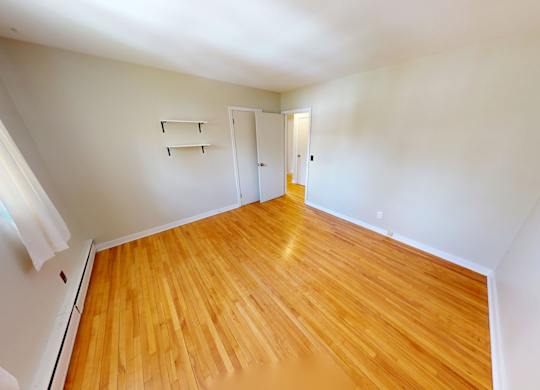 A room with wooden flooring and white walls.