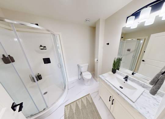 A modern bathroom with a glass shower stall and a sink vanity.