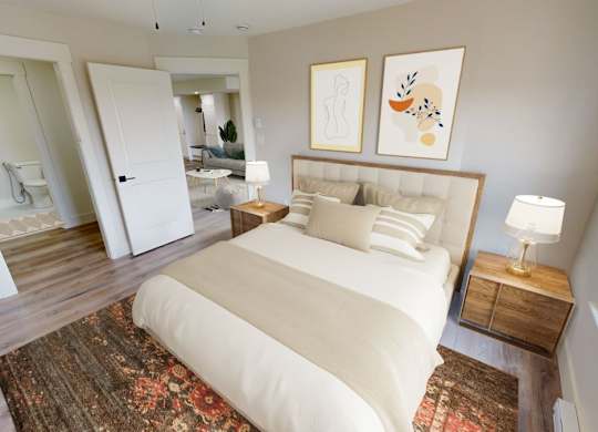 A bedroom with a large bed and a rug on the floor.